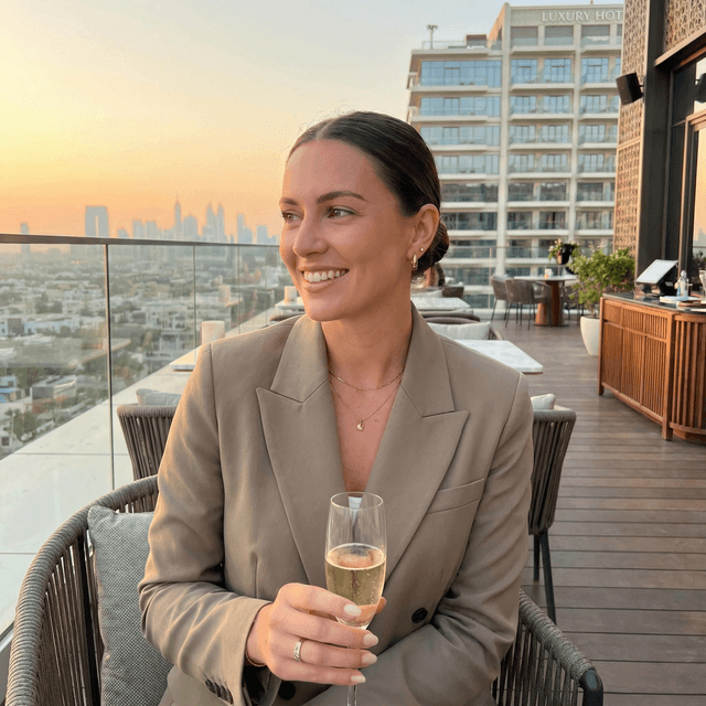 professional dating profile photo, person with genuine smile, well-lit outdoor setting with natural background, casual stylish outfit, confident approachable expression, soft natural lighting