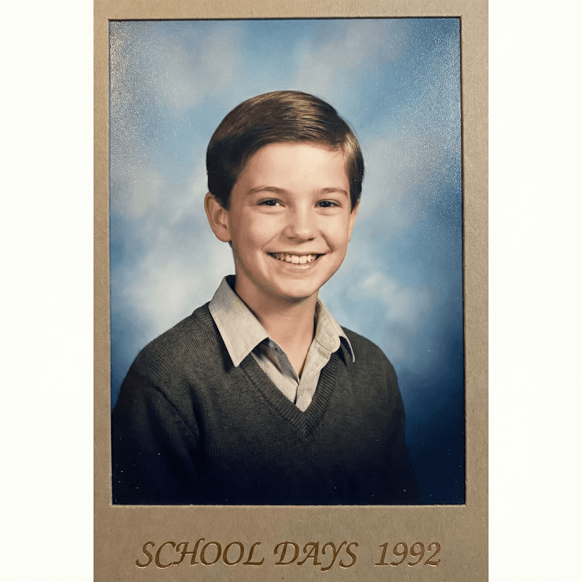 Classic school portrait photo, gradient blue backdrop, neat appearance, friendly smile, shoulders and head framing, studio lighting, traditional school photo style