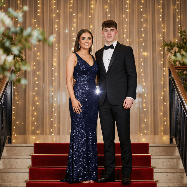 Glamorous prom portrait, formal evening attire, elegant backdrop with fairy lights, confident pose, professional event photography, sparkle and glamour