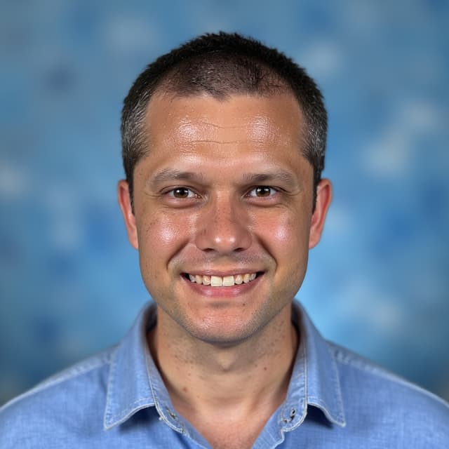 Classic yearbook photo of a smiling high school student with a blue background