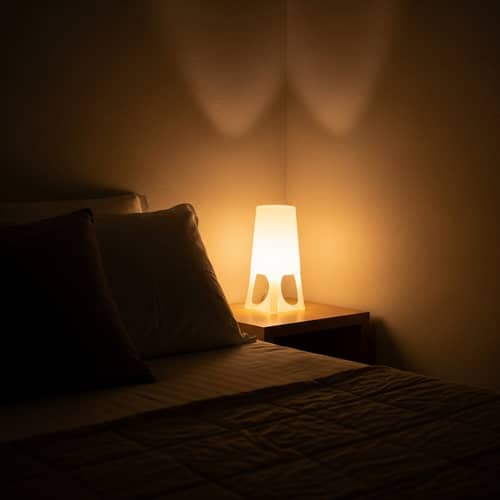 Relaxing Bedroom Scene with Cozy Lamp and Bedspread