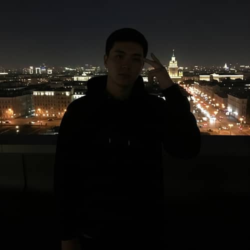 Asian Man Contemplates on Moscow Rooftop at Night