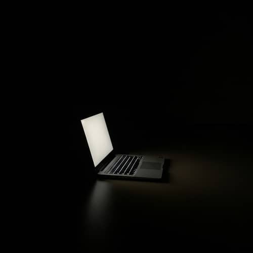 Dark Room Laptop Glow: Eerie Shadows & Subtle Light