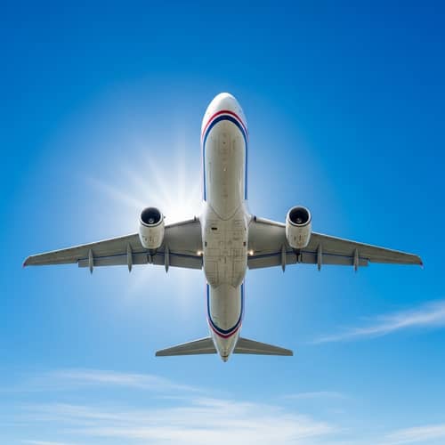 Gleaming White Airplane Soaring Through Clear Blue Sky
