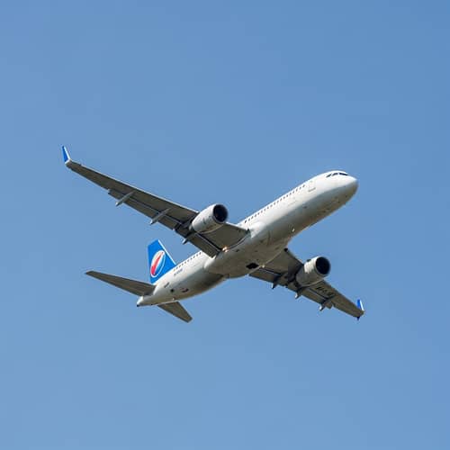 Sleek Commercial Jet Soaring in Clear Sky | Airplane Image