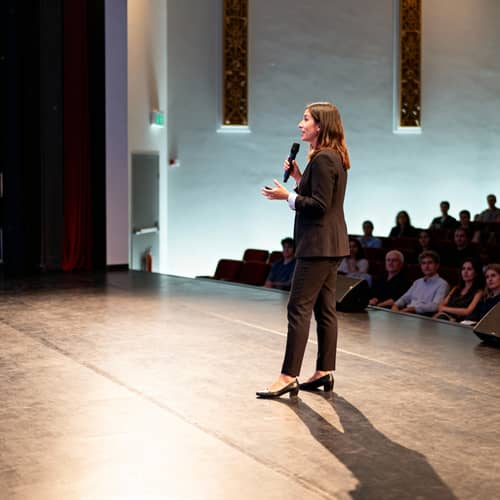 Female Speaker Inspires Audience on Stage Female Speaker Inspires Audience on Stage