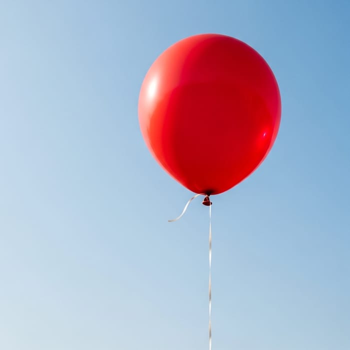 Vibrant Red Balloon Cartoon in Azure Sky