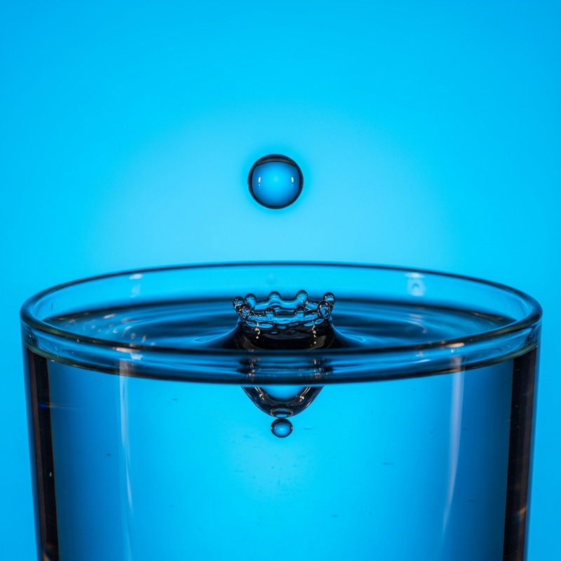Mesmerizing Water Droplet Falling into Aqua Glass Mesmerizing Water Droplet Falling into Aqua Glass