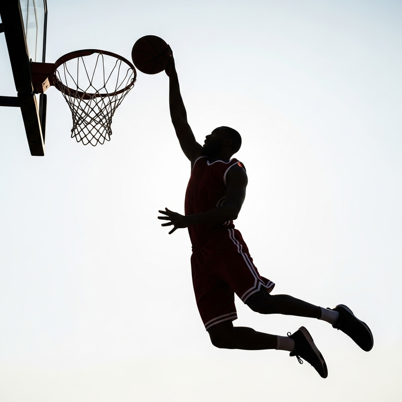 Silhouette of Basketball Player Going for Layup at Rim Silhouette of Basketball Player Going for Layup at Rim