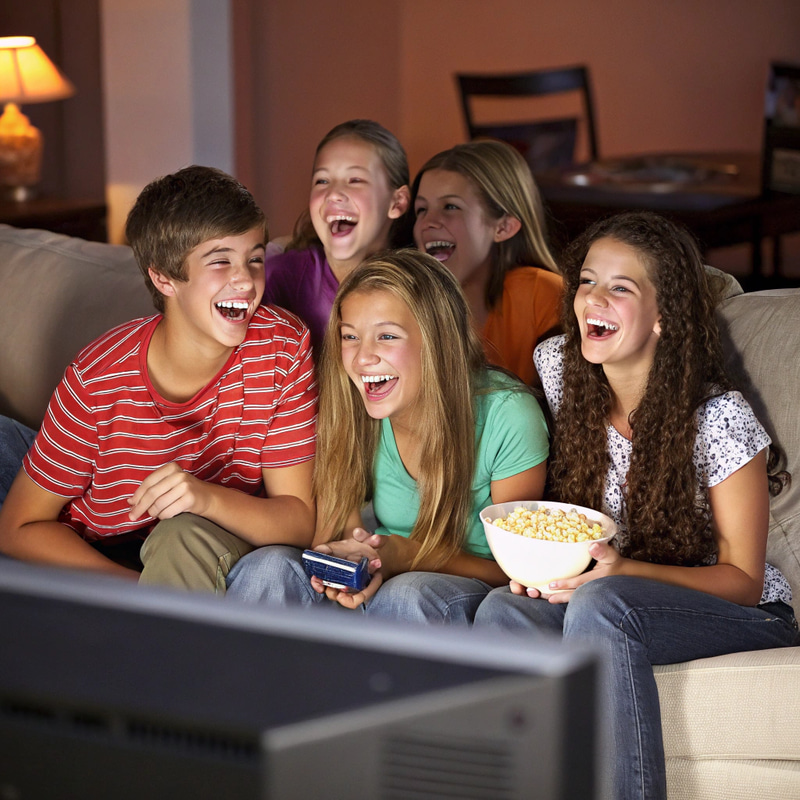 Teenagers Laughing on Couch While Watching TV Teenagers Laughing on Couch While Watching TV